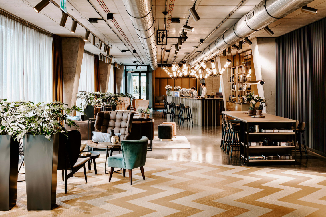 Lobby ze strefą recepcyjno-barową w centralnym punkcie to również dwa stanowiska do samodzielnego zameldowania i pracy oraz jedenaście stref kameralnych spotkań, fot. Vienna House Vienna House Mokotow Warsaw świętuje pierwszą rocznicę. Zmierza w kierunku zrównoważonego rozwoju i społecznej odpowiedzialności